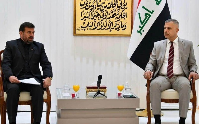 مسؤولان عراقي وإيراني خلال اجتماع أمني بحضور العلم العراقي