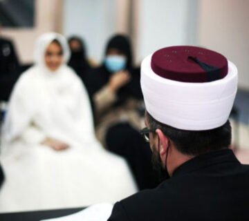 مأذون شرعي أثناء مراسم عقد القِران بحضور العروسين والعائلة 