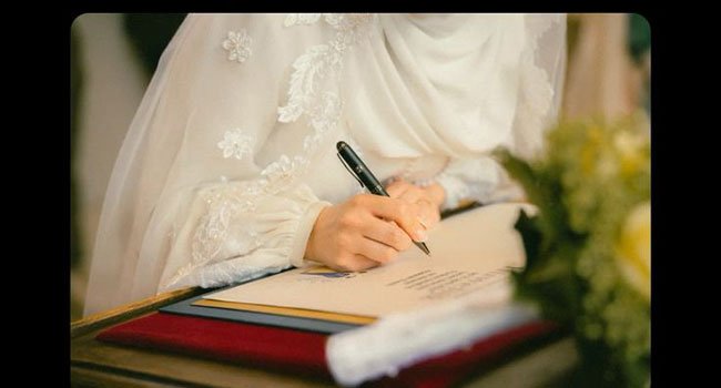 توقيع وثيقة عقد القِران ضمن مراسم الزواج البغدادية.
