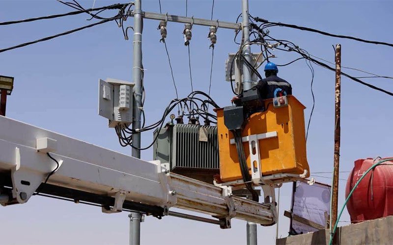 فني كهرباء يعمل على صيانة محولة ضمن شبكة التوزيع 