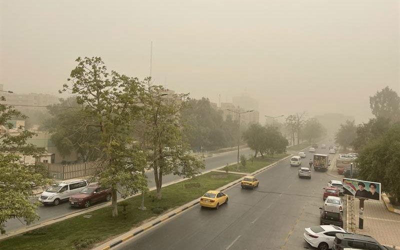 شارع في مدينة عراقية تسوده أسباب الرؤية المنخفضة بسبب الغبار في السماء 