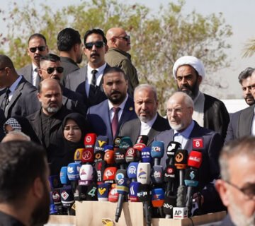 رئيس مجلس الشورى الإيراني محمد باقر قاليباف يتحدث خلال مؤتمر صحفي في بغداد محاطاً بالمسؤولين والصحفيين وأمامه مجموعة كبيرة من الميكروفونات 