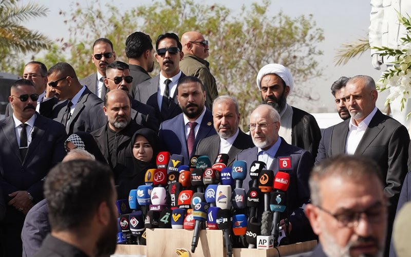 رئيس مجلس الشورى الإيراني محمد باقر قاليباف يتحدث خلال مؤتمر صحفي في بغداد محاطاً بالمسؤولين والصحفيين وأمامه مجموعة كبيرة من الميكروفونات 