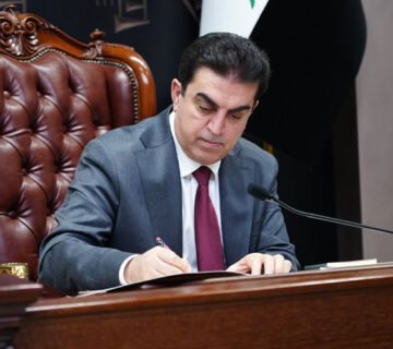 مسؤول عراقي (الأتروشي) يجلس على كرسي جلدي فخم