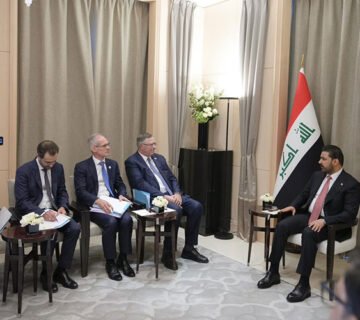 لقاء جمع رئيس الوزراء العراقي بوفد أجنبي في قاعة اجتماعات بجانب العلم العراقي 