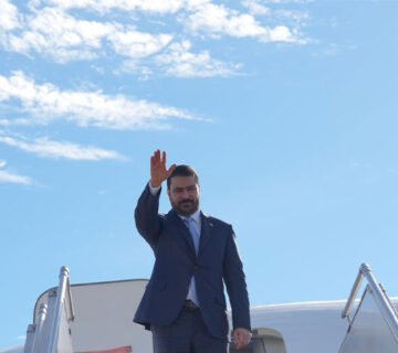 رئيس الوزراء العراقي يلوّح بيده عند أعلى سلم الطائرة لدى وصوله برلين 