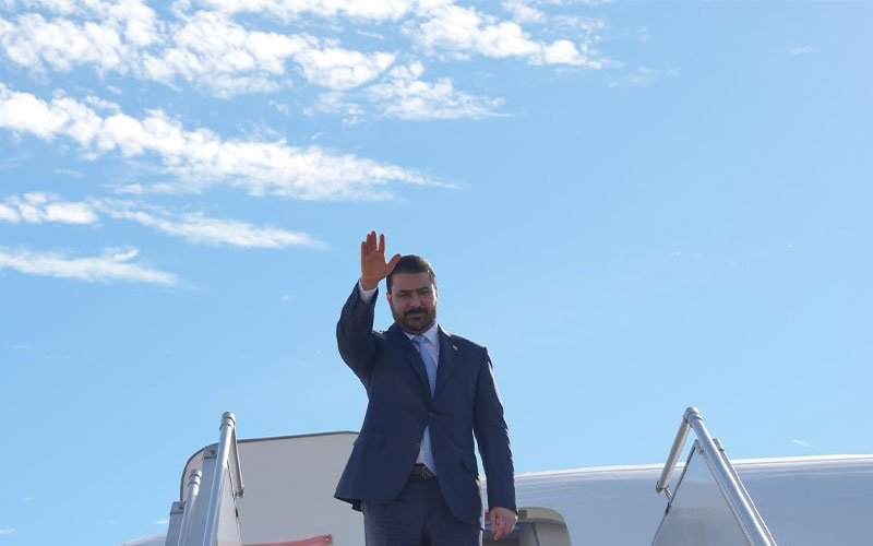 رئيس الوزراء العراقي يلوّح بيده عند أعلى سلم الطائرة لدى وصوله برلين 