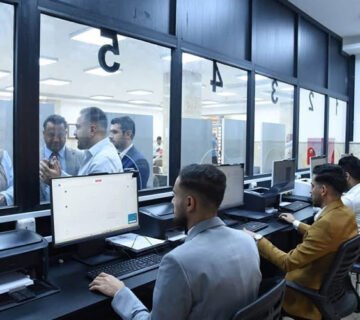 موظفون يعملون على أجهزة الحاسوب في مديرية تنفيذية عراقية 