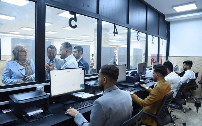 موظفون يعملون على أجهزة الحاسوب في مديرية تنفيذية عراقية 